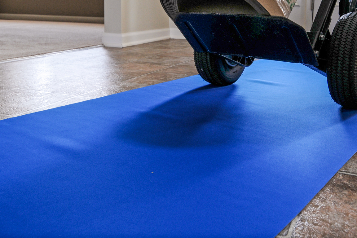 A blue protective surface for floors under a dolly cart.
