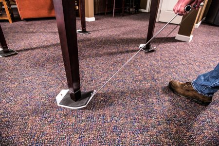 Two black plastic sleds, designed for moving heavy objects across a carpet surface.