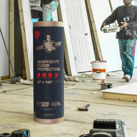 A roll of builder board surface protection in packaging on a construction site where painters are working