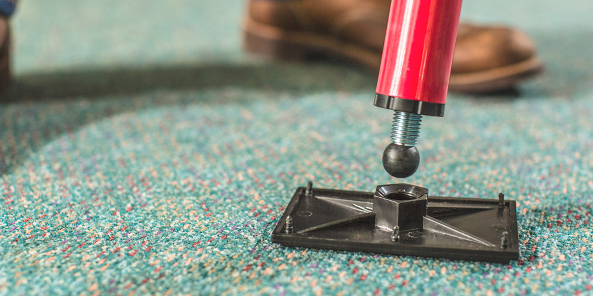 A close-up picture of a pole base over a carpet.