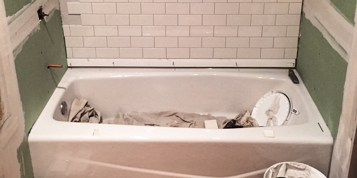 Photo of a bathtub in a bathroom that is being remodeled.