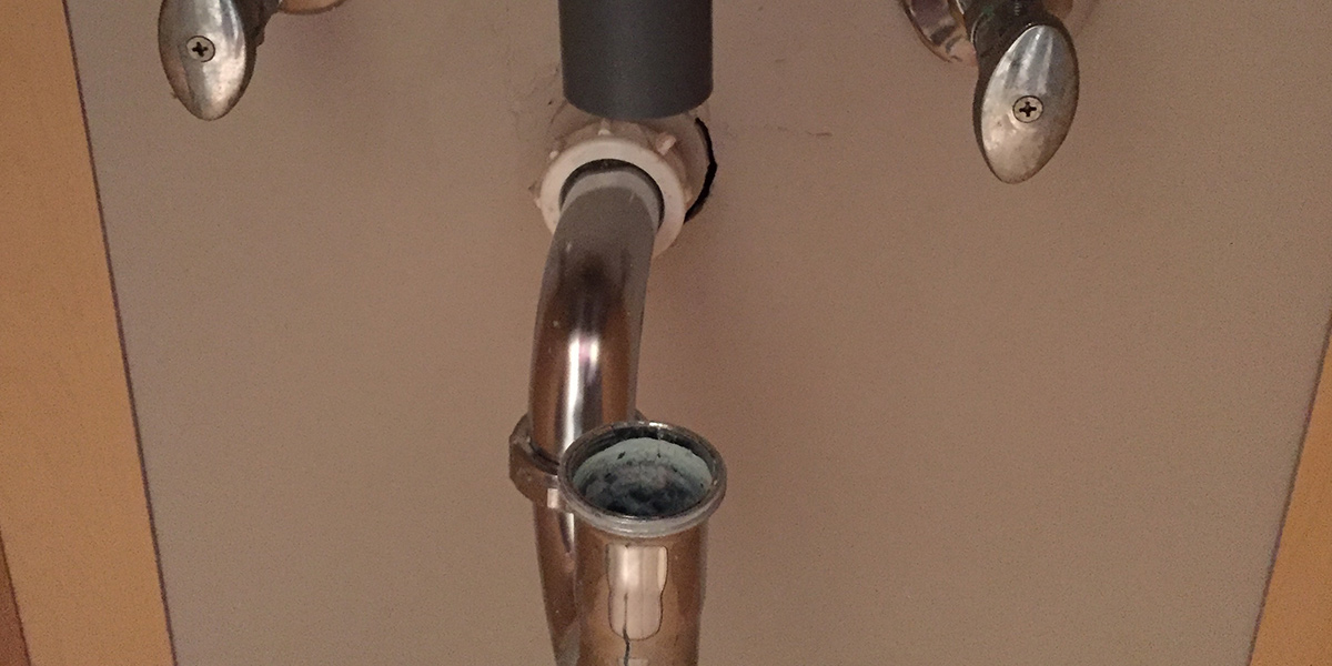 A photo of the plumbing of a sink.
