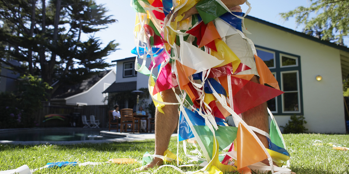 A close-up picture of a man's legs covered with multicolor plastic bunting.