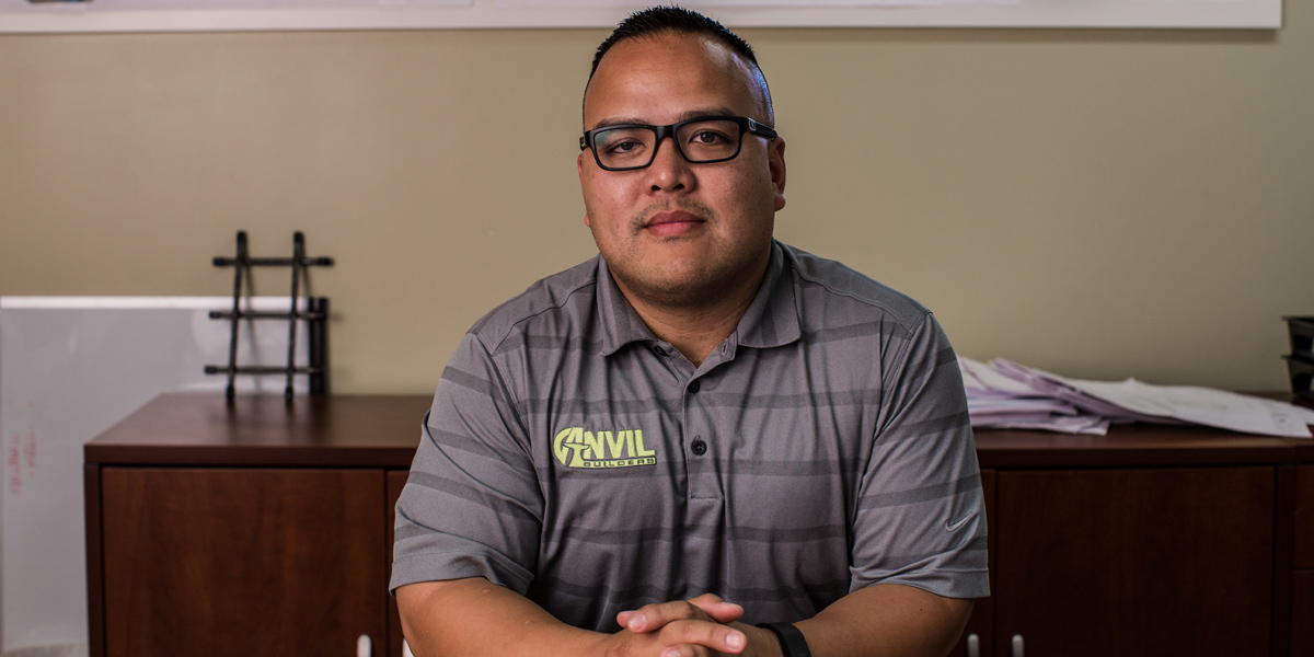 Man with glasses sitting at a desk.