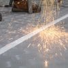 sparks from an angle grinder landing on grey flame retardant floor protection