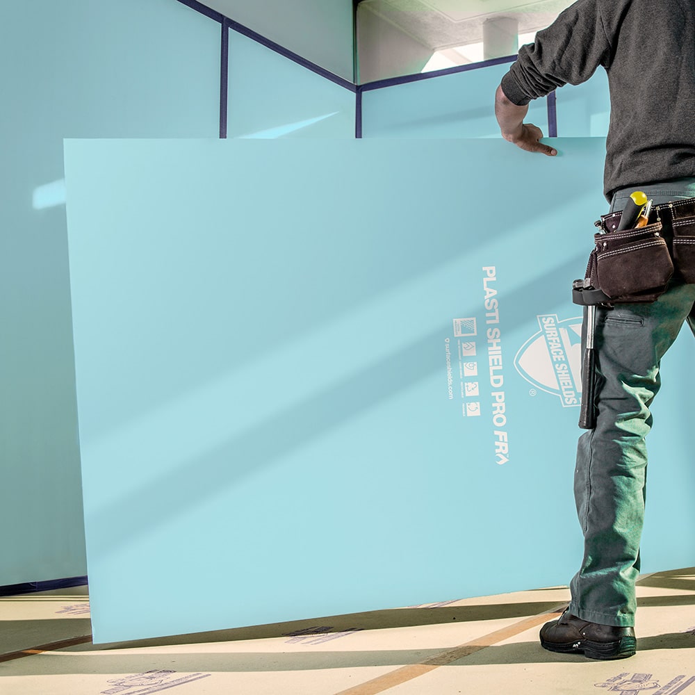 A man standing in front of a blue surface protector.