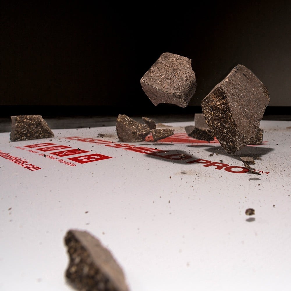 Several fallen rock fragments on a white protective surface.