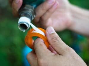 applying white thread seal tape to pipe fitting